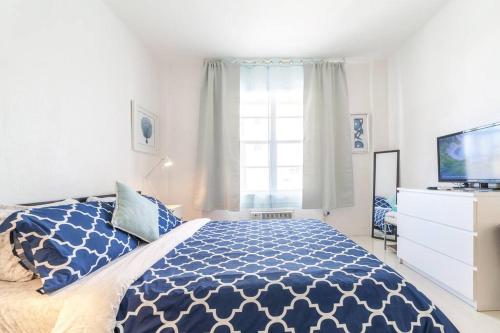 a bedroom with a blue and white bed and a television at 2 BEDROOM ON THE BEACH ! in Miami Beach