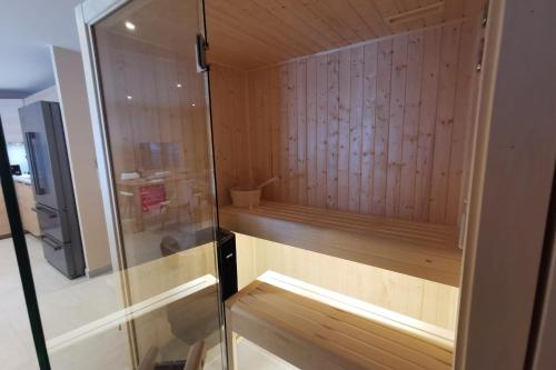 a sauna with wooden walls and a glass door at L'écrin des neiges - Sauna in La Féclaz