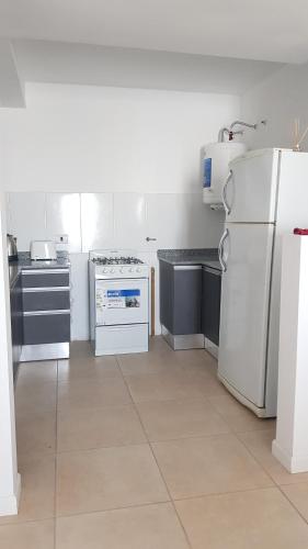 eine Küche mit weißen Geräten und einem weißen Kühlschrank in der Unterkunft APART HOME 2 in Río Cuarto