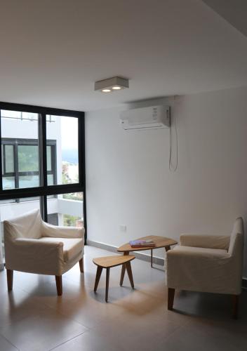 a living room with two chairs and a table at Departamentos Ciudad de Nieva in San Salvador de Jujuy