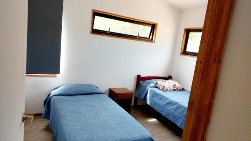 a small bedroom with two beds and a mirror at Algarrobo Casa Canelo in Algarrobo