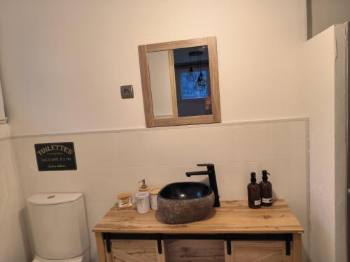 a bathroom with a sink and a mirror on a table at La sapinette in La Bâthie