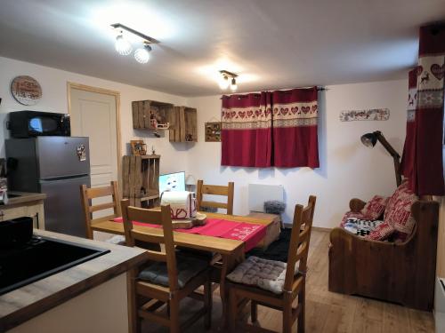 a kitchen with a table and chairs in a room at La sapinette avec jaccuzzi in La Bâthie