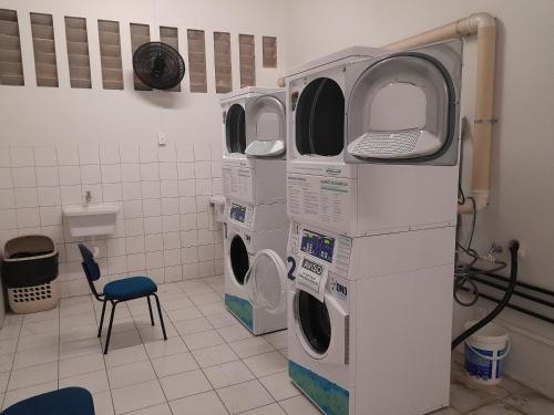 two washing machines in a laundry room with a chair at FLAT SAINT MARTIN Apto 308 in Fortaleza