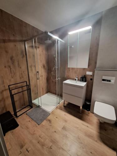 a bathroom with a glass shower and a sink at Apartament Drwęcka in Ostróda