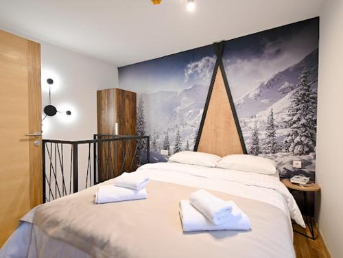 Un dormitorio con una cama grande con un cuadro en la pared. en Grand Apartman Jahorina, en Jahorina