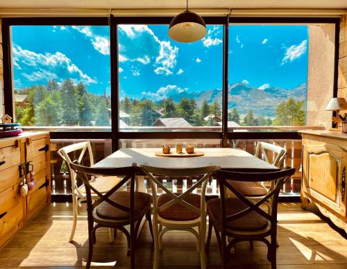 een keuken met een tafel en stoelen en een groot raam bij Appart 5pers joue du loup pied de pistes vue top in La Joue du Loup