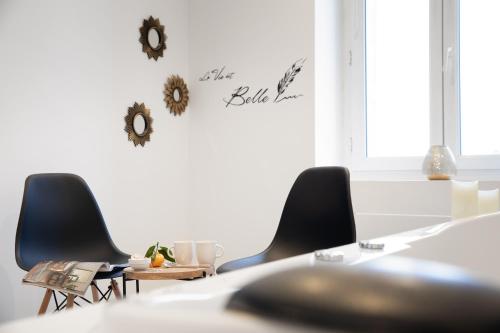 ein Esszimmer mit Stühlen und einem Tisch mit einem Schild an der Wand in der Unterkunft Cinéma & Jacuzzi aux Étoiles - CasaBianca Suite in Saint-Étienne