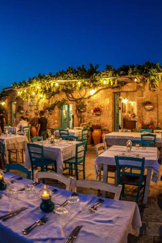 a restaurant with white tables and chairs and lights at La Casa sulla Spiaggia in Marzamemi