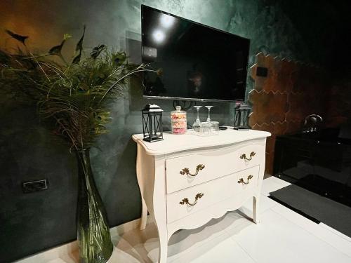 a white dresser with a vase of flowers on it at Spa Apartments UTOPIA in Belgrade