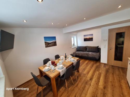 a dining room with a table and chairs and a couch at Apart Klomberg in Landeck