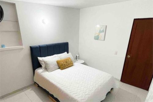 Dormitorio pequeño con cama con cabecero azul en Casa Luna Llena, en Cali
