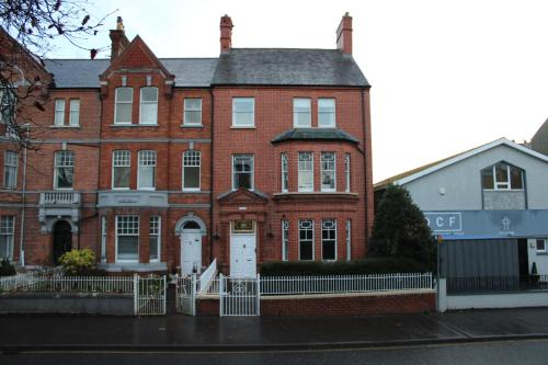 un grande edificio in mattoni rossi con una porta bianca di Station Rooms a Londonderry County Borough