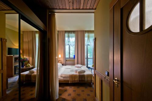 a bedroom with a bed and a large window at BEST BALTIC Hotel Druskininkai Central in Druskininkai