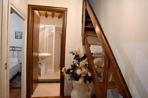 ein Badezimmer mit einer Treppe und einer Vase mit Blumen in der Unterkunft Palazzo Granaroli in Bagnoregio