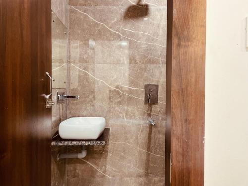 y baño con ducha y aseo. en The Ganga Divine - A Family Hotel, en Haridwar