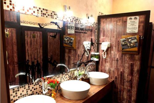 a bathroom with two sinks and a wooden wall at DRIMIN by sunrise caravan - Family boutique guesthouse and hostel in Tashkent