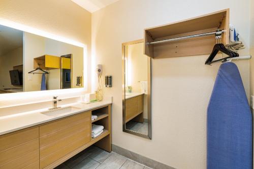 a bathroom with a sink and a mirror at Palace Inn Blue-IAH East in Humble