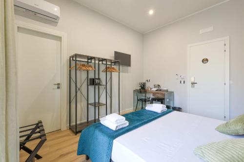 a white bedroom with a bed with towels on it at Cuore Napoli Centro in Naples