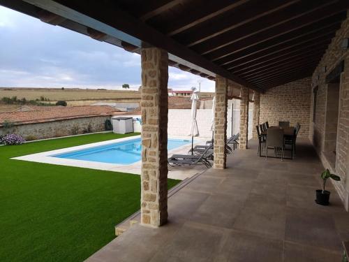 a patio with a pool and a table and chairs at Casa Rural: La Tarara 