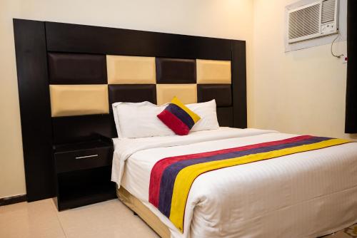 - une chambre avec un grand lit et une tête de lit noire dans l'établissement Tara One Apartment By Alin, à Riyad