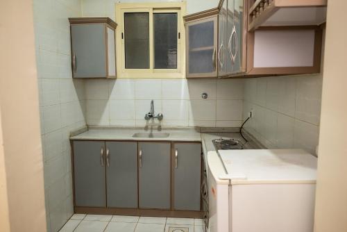 Il comprend une petite cuisine équipée d'un évier et d'une cuisinière. dans l'établissement Tara One Apartment By Alin, à Riyad