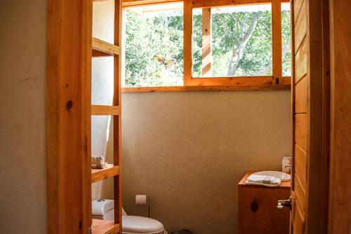 a bathroom with a toilet and a window at Casa Curativa in Tzununá