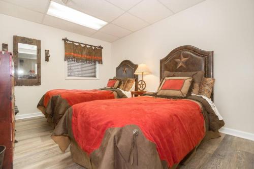 1 dormitorio con 2 camas y edredón rojo en 30 acre horse ranch with Bunk House, 
