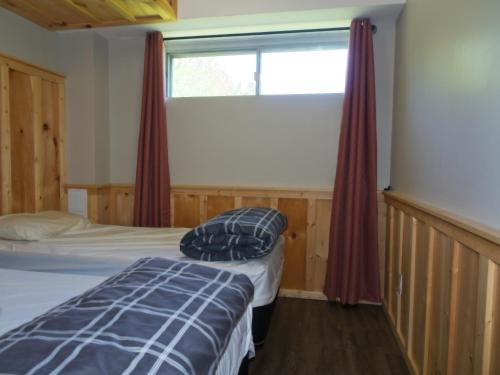 ein Schlafzimmer mit einem Bett und einem Fenster mit roten Vorhängen in der Unterkunft Gateside Chalets 6 Bedroom Hot Tub Near Village in Blue Mountains