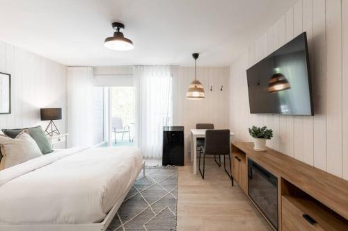 - une chambre avec un lit, une table et une télévision dans l'établissement Luxurious & Modern Tremblant Loft Pool&Spa Access, à Mont-Tremblant