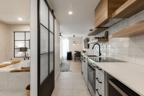 a kitchen with a sink and a counter top at Luxurious & Modern Tremblant Loft Pool&Spa Access in Mont-Tremblant