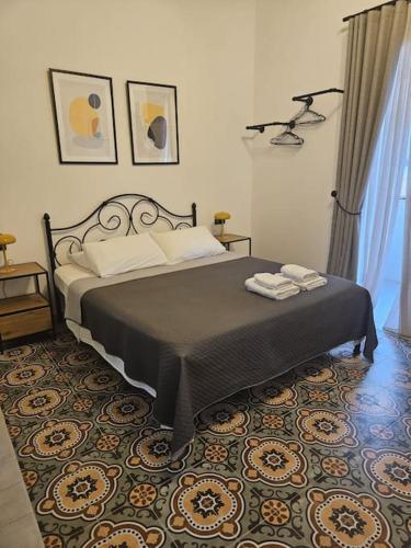 a bedroom with a bed with two towels on it at Ivy - Paola Modern Townhouse in Paola