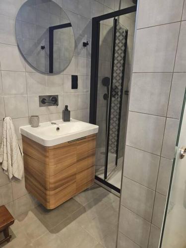 a bathroom with a sink and a shower with a mirror at Ivy - Paola Modern Townhouse in Paola