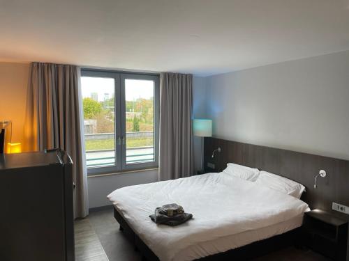 a bedroom with a bed and a large window at Hafen Pano Lux Appartment +Küche+TV+AC+TG+View in Düsseldorf