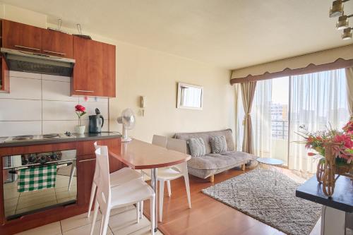 cocina y sala de estar con mesa y sofá en Departamento 2 dormitorios 2 baños + parking en Santiago