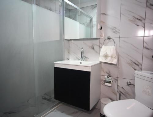 La salle de bains blanche est pourvue d'un lavabo et de toilettes. dans l'établissement Shared apartment at Şişli(private room), à Istanbul