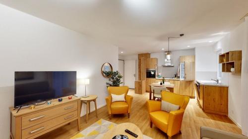 uma sala de estar com uma grande televisão e cadeiras amarelas em Alp Art Hotel em Collombey