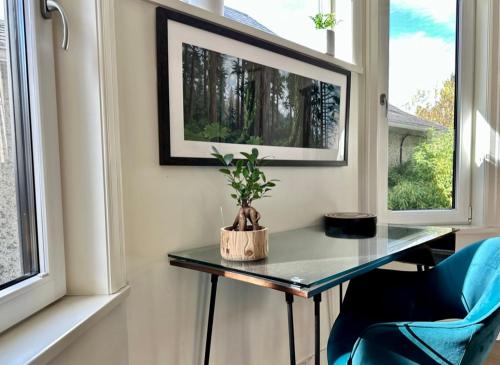 stół i krzesło w pokoju z oknami w obiekcie Vineyard Suite at The Inn On The Drive w mieście Vancouver