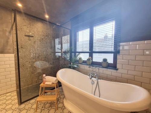 a bathroom with a tub and a glass shower at Dream@coast in Nieuwpoort