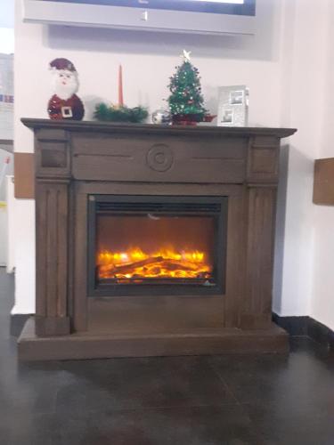 a fireplace with a christmas tree on top of it at Hanul Anitei La paducel 