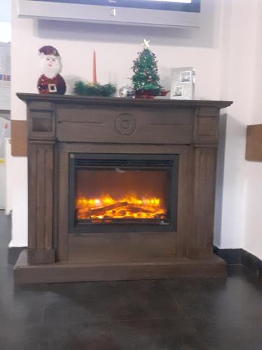 una chimenea con un árbol de Navidad encima en Hanul Anitei La paducel 