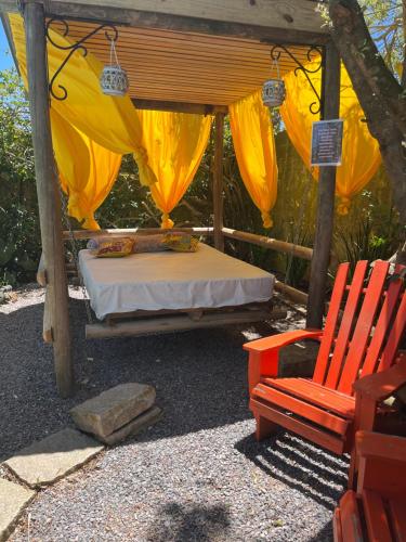 a bed and a chair under a gazebo at Paz y armonía en Chuy in Chuy