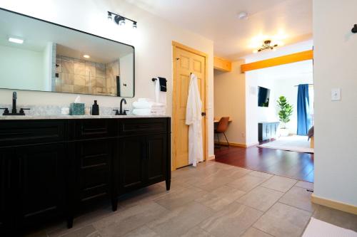 uma casa de banho com um toucador preto e um espelho grande em Serene Mountainside Retreat em Fairplay