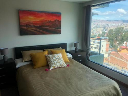 ein Schlafzimmer mit einem großen Bett und einem großen Fenster in der Unterkunft HABITARE in La Paz