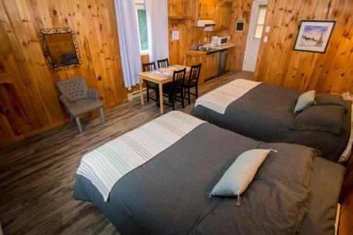 a bedroom with two beds and a kitchen with a table at Centre de Vacances 5 Étoiles Family Resort in Sacré-Coeur-Saguenay