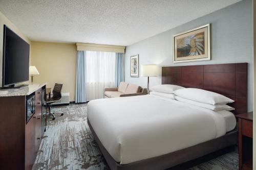 Cette chambre comprend un grand lit et une télévision. dans l'établissement DoubleTree by Hilton Rocky Mount, à Rocky Mount
