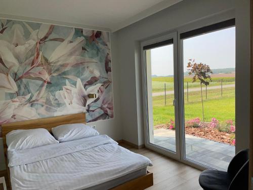 una camera da letto con un letto e una porta scorrevole in vetro di Leśny Horyzont Bałtów a Bałtów