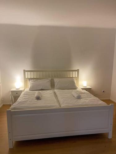 ein weißes Bett mit zwei Lampen an zwei Tischen in der Unterkunft The perfect Place 