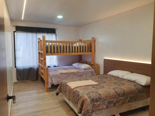 1 dormitorio con 2 camas y 1 litera en Viento Susurrante, en Santa Isabel