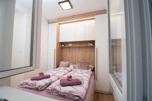 een slaapkamer met een bed met 2 kussens erop bij Cute 1BDR in City Center in Sarajevo